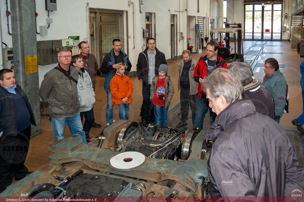 Foto der Teilnehmergruppe im Betriebshof Rosengarten in der Werkstatthalle beim Betrachten eines Drehgestells des Niederflurwagens MGT6D