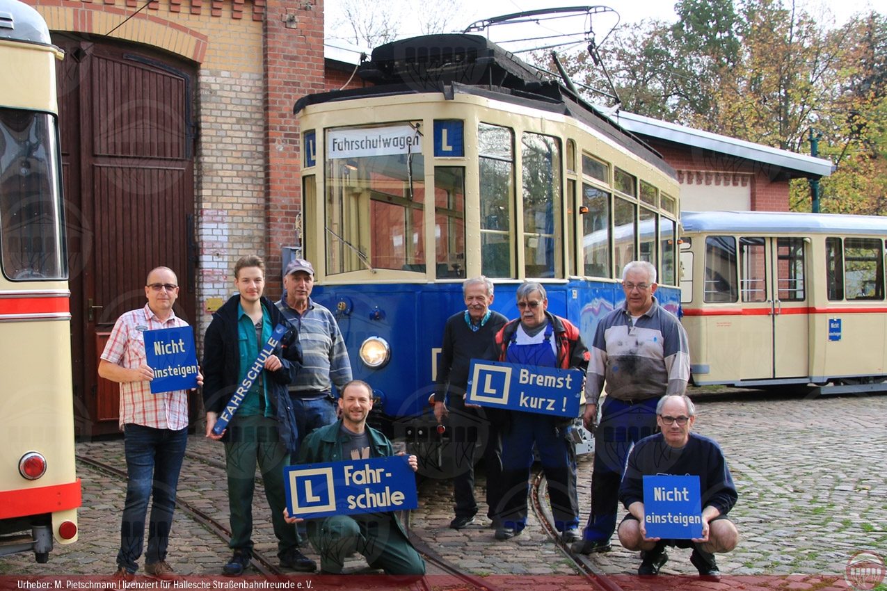 Foto von Vereinsmitgliedern vor dem historischen Fahrschulzug